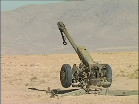 Slo-mo shot of Howitzer being fired in desert. Stock Footage 10577722