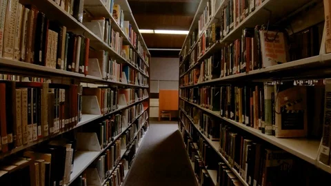 Slo-Mo shot walking through an aisle of a public library. Stock Footage 109099391