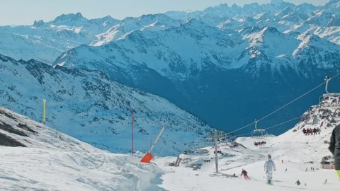 Slo-mo of snowboarder jumping at a ski slope with ski lift in the beautiful alps Stock Footage 71125886