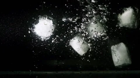 Slo Mo studio shot of ice cubes falling in water on black background. Stock Footage 205537628