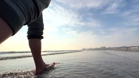 SLO MO TS Barefoot man running on the beach at sunset Stock Footage 234697247