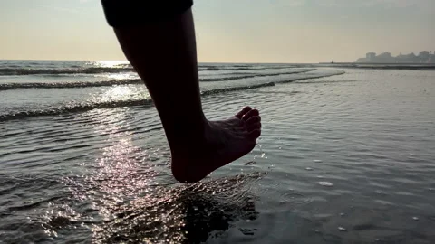 SLO MO TS Man walking along the beach at sunset Stock Footage 234720094