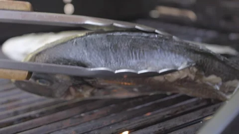 SLO MO Turning a fish on the grill Stock Footage 244969647