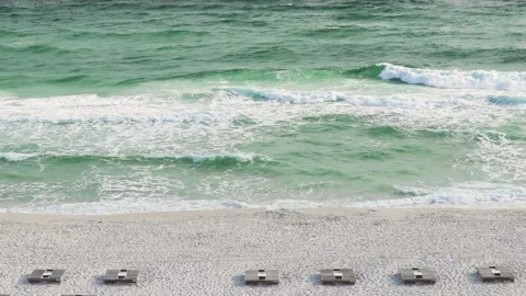 Slo Mo Waves Crashing on Florida Gulf Coast Beach with Empty Commercials Chairs  Stock Footage 133097908