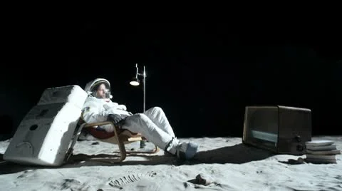 SLO MO, WS, Lockdown, astronaut on the moon sitting in an easy chair, watching Stock Footage 10700492