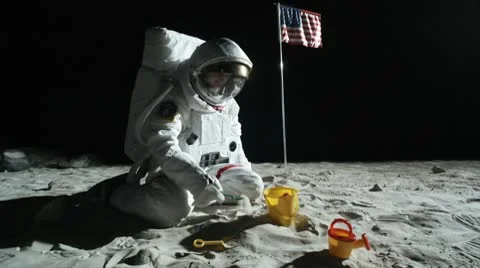 SLO MO, WS, ZO of an astronaut sitting on the moon's surface playing with a sand Stock Footage 10700643