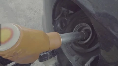 SLO MO Young uses her smartphone while she re-filling fuel in her car Offroad Stock Footage 256721806