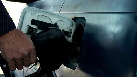 SLO MO Young uses her smartphone while she re-filling fuel in her car Offroad Stock Footage 256723056