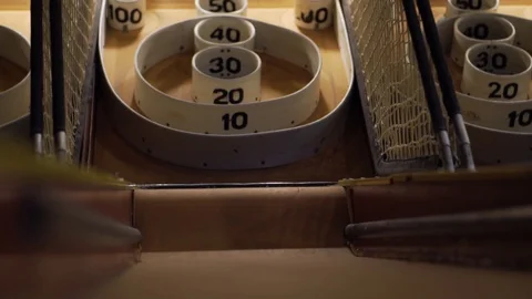 Slo-motion low angle shot of the skee-ball ramp as a ball rolls past and fall Stock Footage 93239438