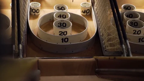 Slo-motion low angle shot of a skee-ball flying towards the 100 point hole. Stock Footage 93239495