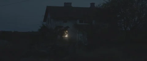SLog shot of a dark house with a single illuminated window Stock Footage 302347506