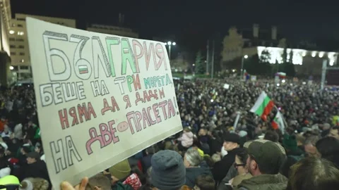 Slogan in Bulgarian with a background of a large protest with flags in Sofia 스톡 동영상 324560537