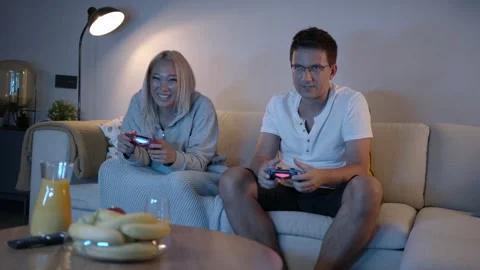 Slomo: Competitive Couple Push And Shove Each Other As They Play Video Games At Stock Footage 135736713