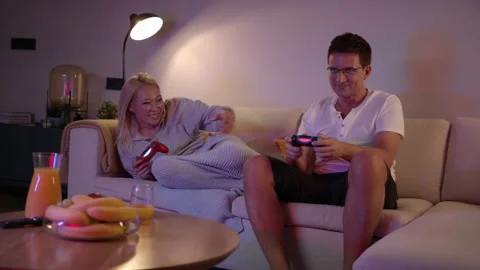 Slomo: Competitive Couple Push And Shove Each Other As They Play Video Games At Stock Footage 135737287