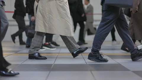 SLOMO Low view of legs walking through Shinagawa Station Stock Footage 295743251