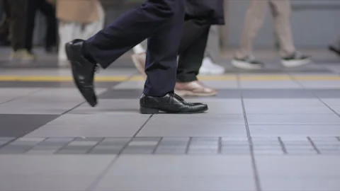 SLOMO Low view of legs walking through Shinagawa Station 動画素材 295743252
