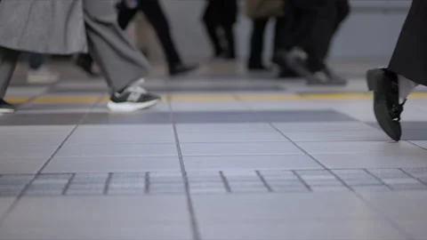 SLOMO Low view of legs walking through Shinagawa Station Stock Footage 295743440