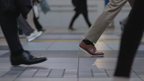 SLOMO Low view of legs walking through Shinagawa Station Stock Footage 295743552