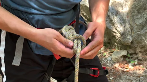 SLOMO Male climber tying a knot Stock Footage 224923053