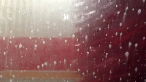 SloMo Soap bubbles on car wind shield from auto car wash with brushes Stock Footage 83982480