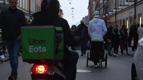 Slomo of Uber Eats moped driving on pedestrian street in Stockholm Stock Footage 178811805