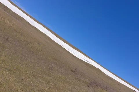 The slope has smooth snow and blue skies. Stock Photos