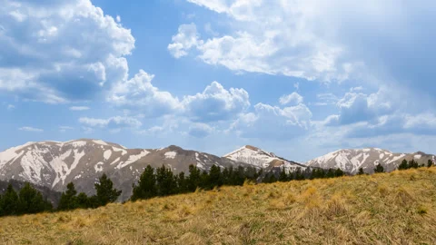 Slope of mount covered by a grass under a blue cloudy sky Stock Footage 333275909