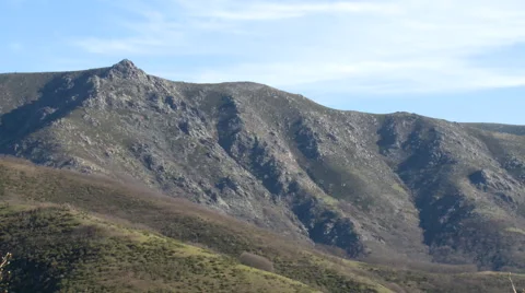 Slope in a mountain range, with high clouds in the sky Stock Footage 49653147