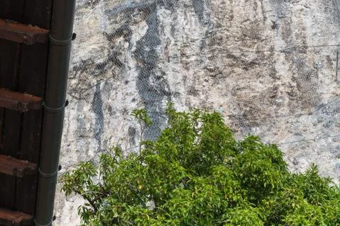 Slope stabilization. Rock face with rockfall protection mesh Stock Photos