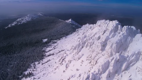 The slopes of ancient mountains , overgrown with forest and covered with snow Stock Footage 126223526