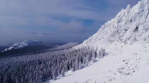 The slopes of ancient mountains , overgrown with forest and covered with snow Stock Footage 126224947