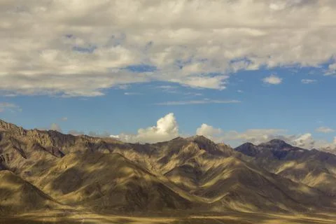 Slopes of desert mountains under the clouds in the afternoon Stock Photos
