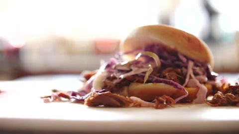 Sloppy messy barbecue pulled pork sandwich being dropped in slow motion Video stock 207924092