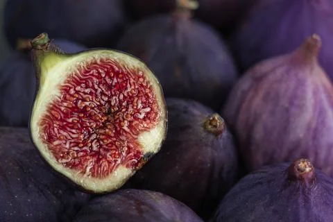 Сlose-up of a fig cut in half lying on a ripe fig. Stock Photos