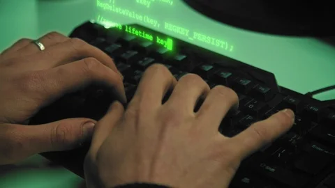 Сlose-up of hacker hands while green code characters fly out of the keyboard in Stock Footage 120666215