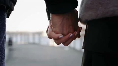 Сlose-up hold hands of a guy and a girl against the backdrop of sunset. Stock Footage 196242349