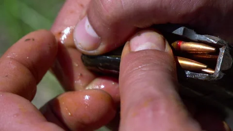 Сlose up shot of hands loading a magazine clip with bullets. Slow Motion Stock Footage 141681460