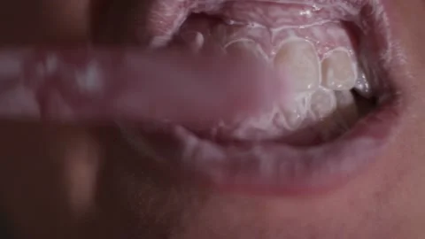 Сlose-up view of person brushing teeth with pink toothbrush and tooth-powder Stock Footage 152128488