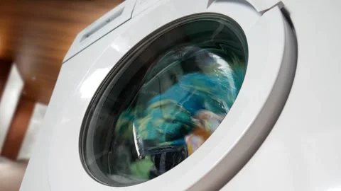 Сlose-up of washable clothes in the drum of a home washing machine Stock Footage 276708616