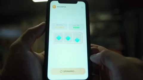 Slot machine app on smartphone screen spinning symbols and hitting jackpot in Stock-Footage 342603602