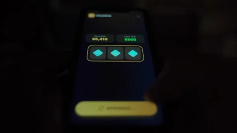 Slot machine app on smartphone spinning symbols and hitting a jackpot win in the Stock-Footage 342811274