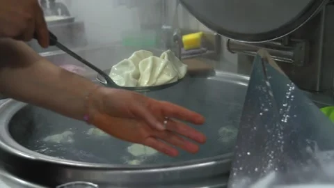 Slotted spoons with cooked khinkali over large cauldron of boiling water Vídeos de archivo 267282986
