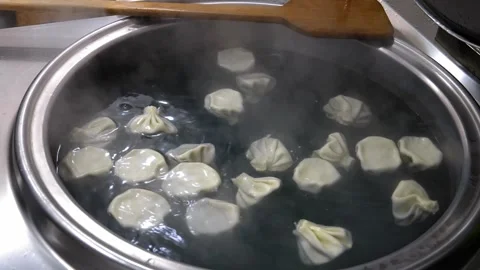 Slotted spoons with cooked khinkali over large cauldron of boiling water Vídeo Stock 267672677