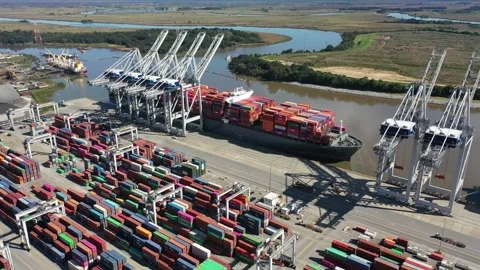 Slow 360 degree pan of container port with ship and cranes 動画素材 163386072