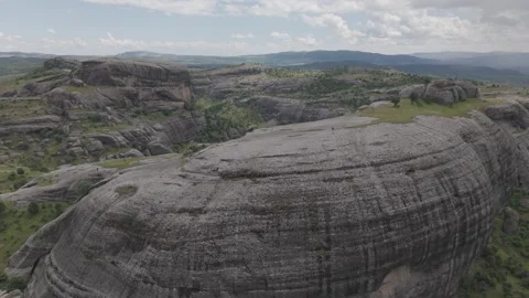 Slow Aerial Descent Toward Massive Rock Formation Stock Footage 344693716
