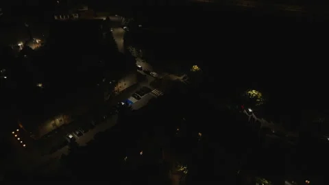 Slow Aerial Dolly Forward Towards Illuminated Building at Night Stock Footage 323769488