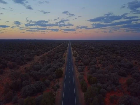 A slow aerial downwards shot of a long road within the vast outback in Australia Stock Footage 79653764