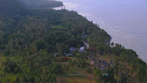 Slow aerial drift from left to right above a luxury tropical village on the Vídeo Stock 345132682