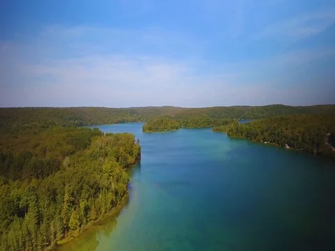 Slow aerial drone flight over fresh water lake in northern Michigan Stock Footage 80896707