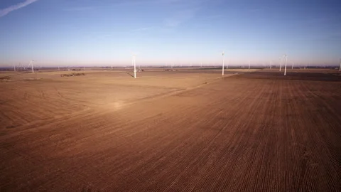 Slow aerial drone orbit of wind turbines under construction Stock Footage 329223199